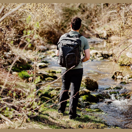 Sac à dos étanche Nomad 35 porté en extérieur près d'un cours d'eau